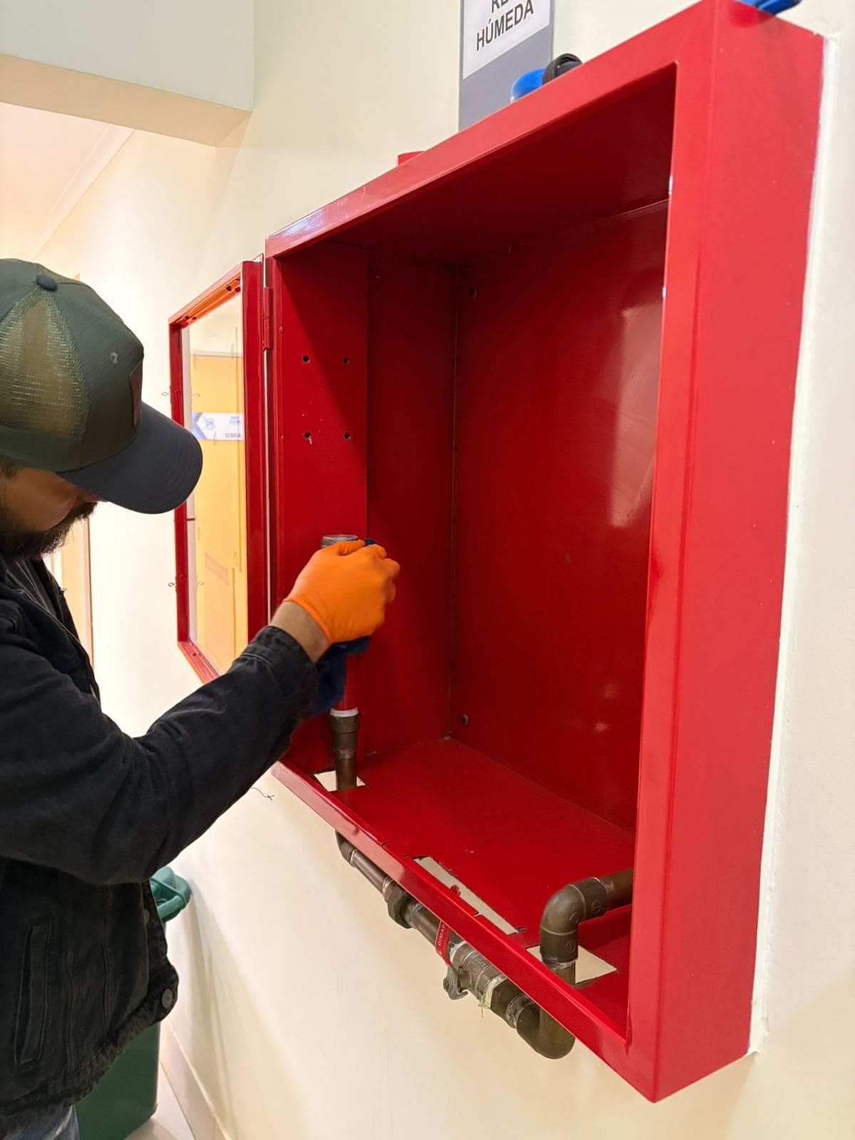 Técnico de Faena manteniendo un gabinete de red húmeda en las instalaciones de un cliente.