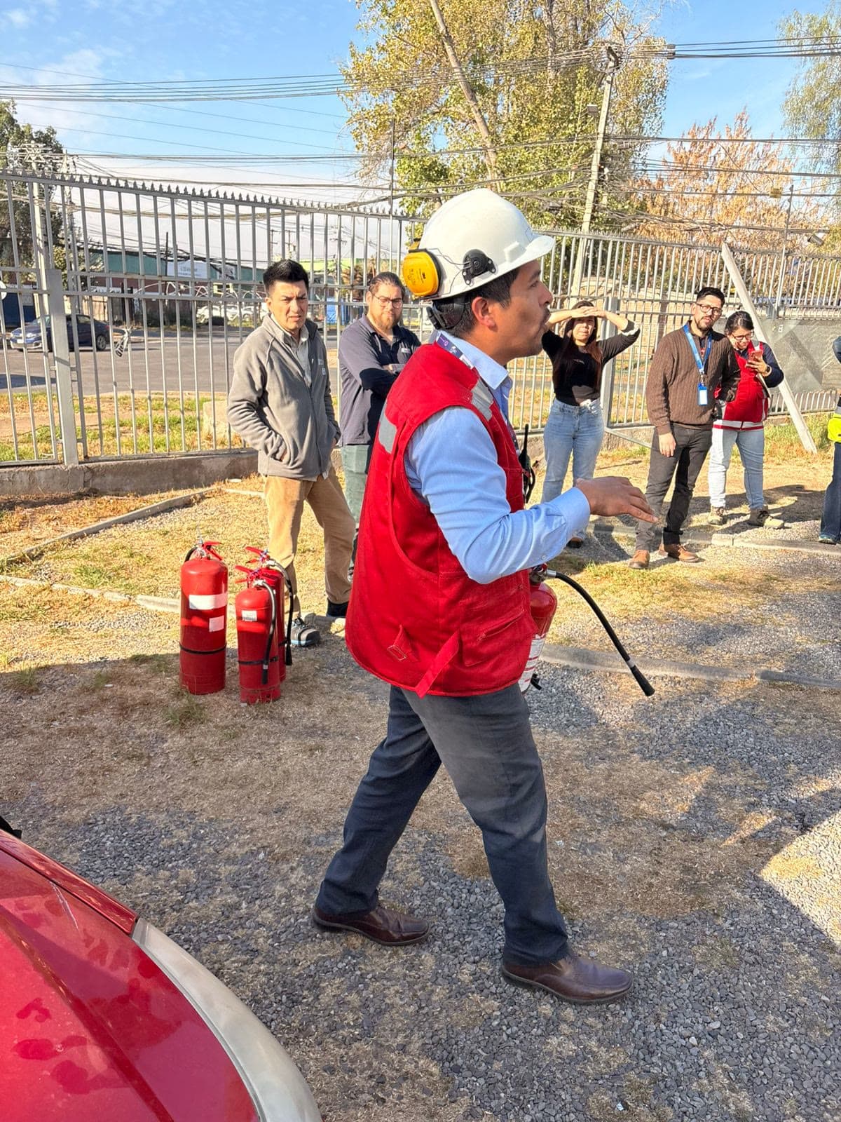 Personal de una empresa reunido en un simulacro de evacuación frente a su edificio corporativo.